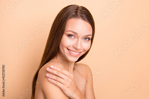 Profile photo of pretty lady hand touching shoulder applying cosmetic no clothing isolated on beige color background