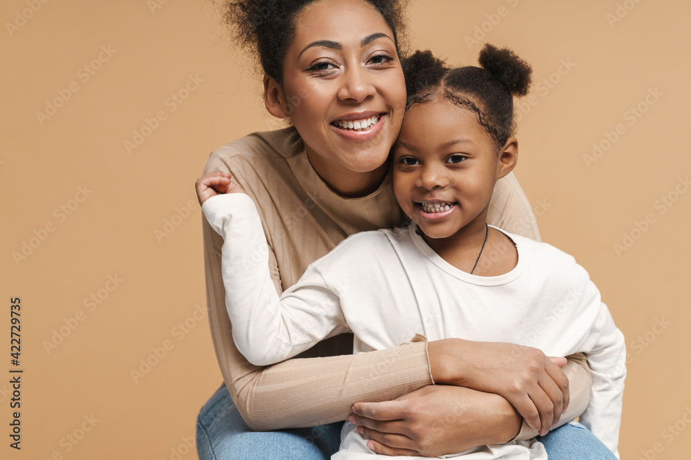 Happy black mother and daughter hugging and smiling Happy black mother and daughter hugging and smiling