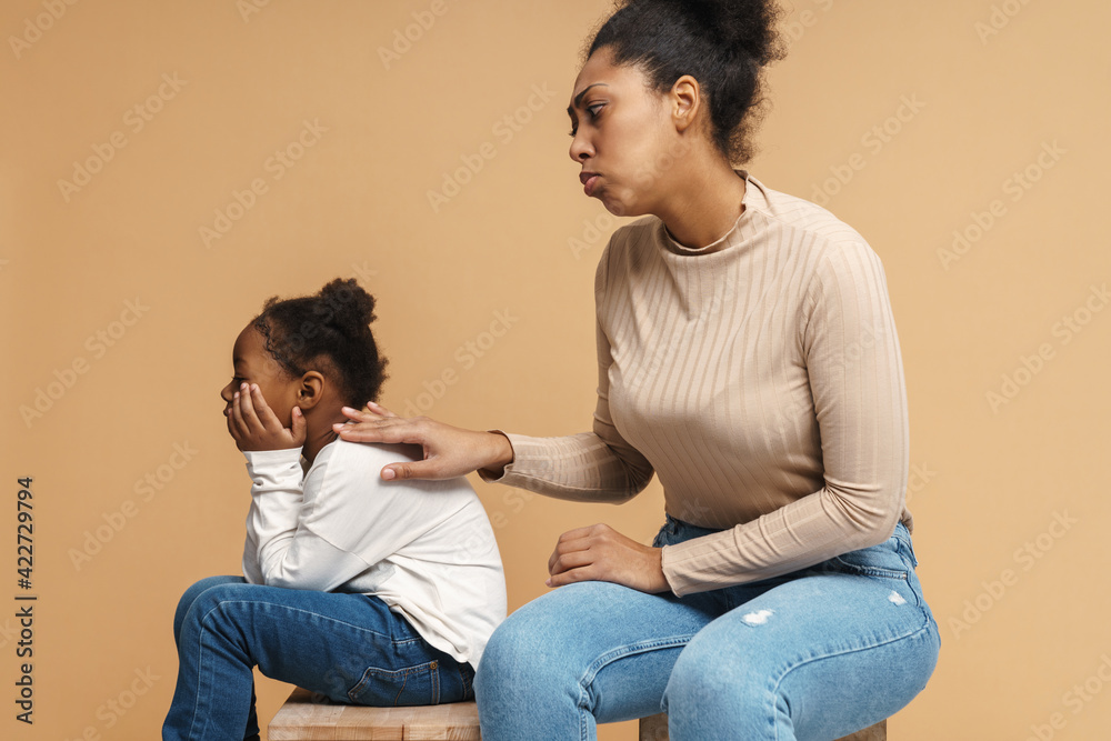 Displeased black mother touching her daughter after argument Displeased black mother touching her daughter after argument