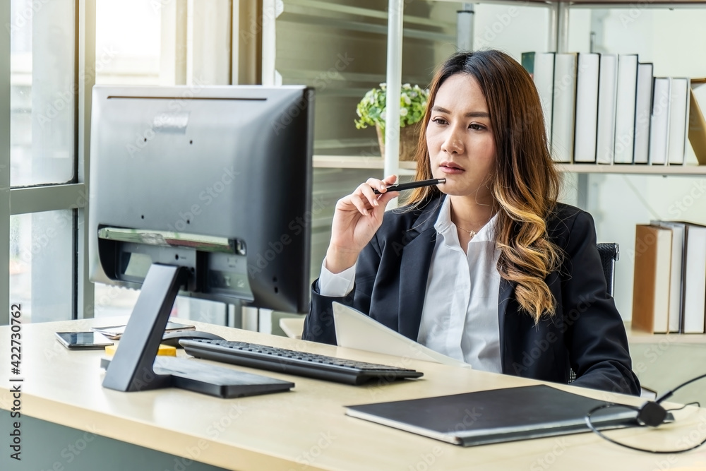 Thoughtful young asian woman thinking using business vision near laptop for calculating finance rates looking at future in office. Girl accounting with check credit analytic for mortgage payment Thoughtful young asian woman thinking using business vision near laptop for calculating finance rates looking at future in office. Girl accounting with check credit analytic for mortgage payment