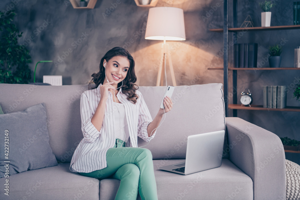 Naklejka premium Photo of optimistic brunette curly hairdo lady work talk telephone from home wear white shirt sit on sofa