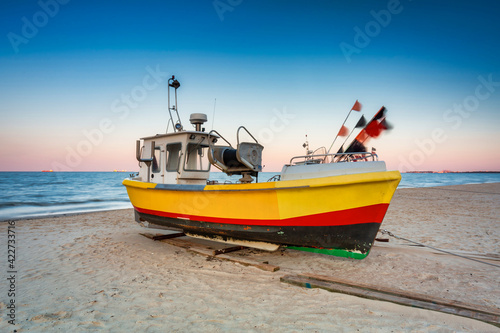 Amazing sunset with fishing boats at the beach of Baltic Sea in Sopot, Poland