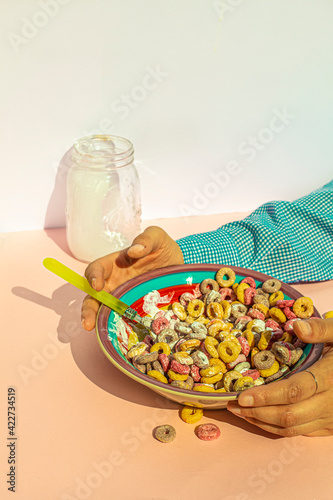 Arm of woman eating colors cereals with milk at vintage kitchen