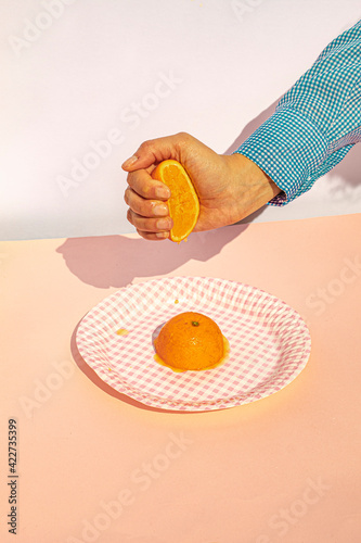 Arm of woman squeezing oranges at vintage kitchen