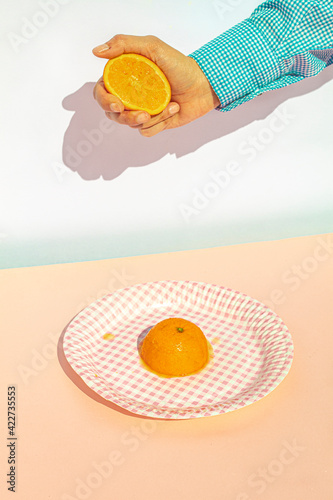 Arm of woman squeezing oranges at vintage kitchen