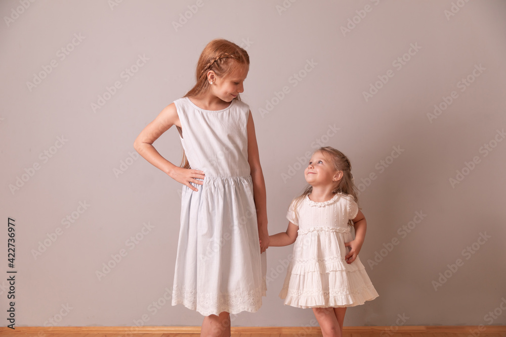 sisters look at each other. girls hold hands sisters look at each other. girls hold hands