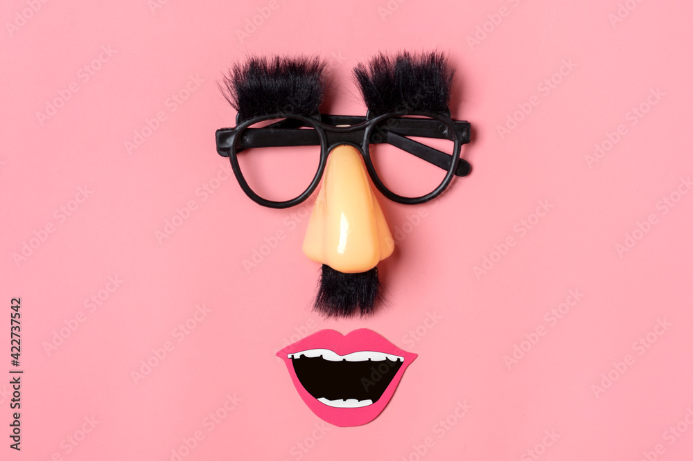 funny face - fake eyeglasses, nose and mustache, confetti, sequins on pink background Happy fools day concept 1st April party Holiday card funny face - fake eyeglasses, nose and mustache, confetti, sequins on pink background Happy fools day concept 1st April party Holiday card
