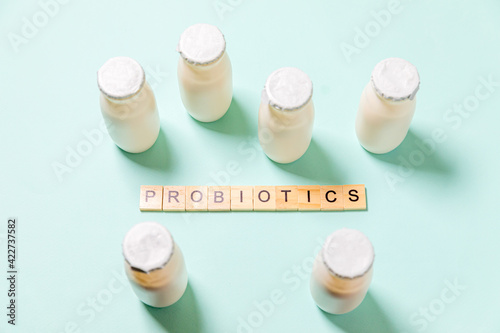 Photography Small bottles with probiotics and prebiotics dairy drink on blue background