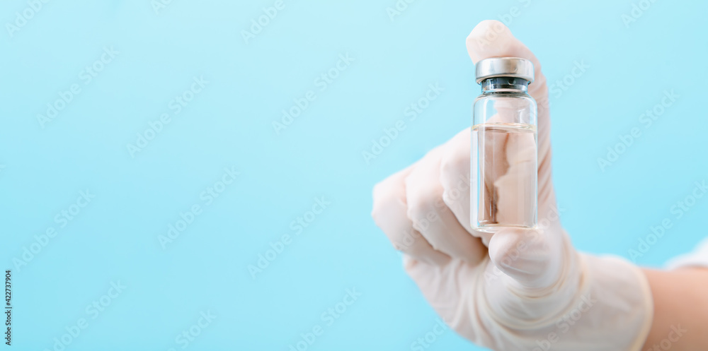 Covid 19 coronavirus Vaccine in glass vial bottle, medicine liquid in doctor hand. Mock up Vaccination injections as treatment. Covid immunization concept Long banner on color background copy space Covid 19 coronavirus Vaccine in glass vial bottle, medicine liquid in doctor hand. Mock up Vaccination injections as treatment. Covid immunization concept Long banner on color background copy space