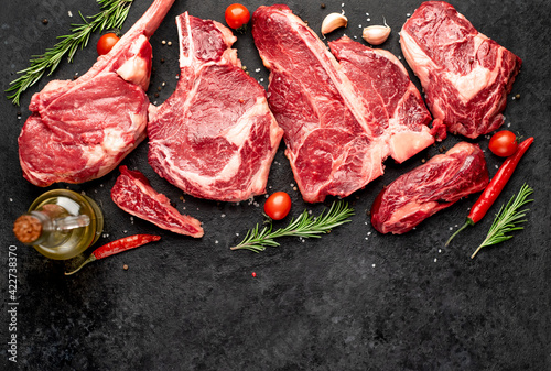 Set of various alternative raw meat steaks, veal-tomahawk steaks, Rib eye steak, T-bone steak, tenderloin, on stone background with copy space for your text