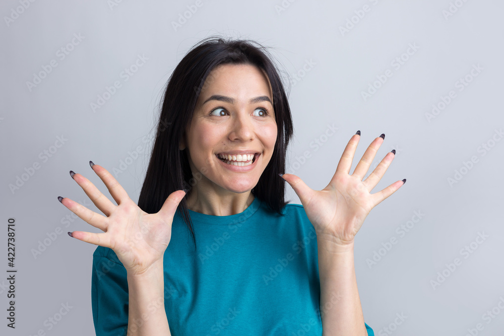 Young beautiful woman with facial expression of surprise standing over gray background. Young beautiful woman with facial expression of surprise standing over gray background.