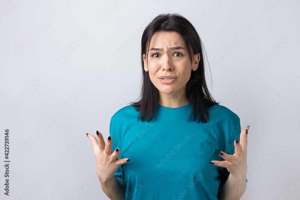 Young beautiful woman with facial expression of surprise standing over gray background. Young beautiful woman with facial expression of surprise standing over gray background.