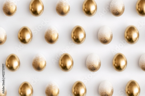 Pattern composition of golden eggs on a white background. Minimal easter concept.