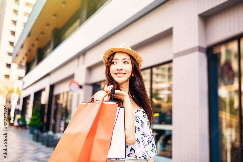 Happy young woman holding shopping bags on the street Happy young woman holding shopping bags on the street