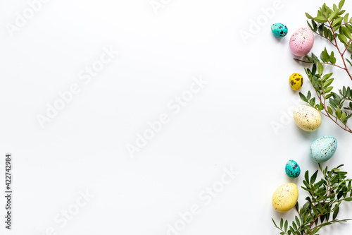 Happy Easter card with colorful eggs and green leaves. Overhead view