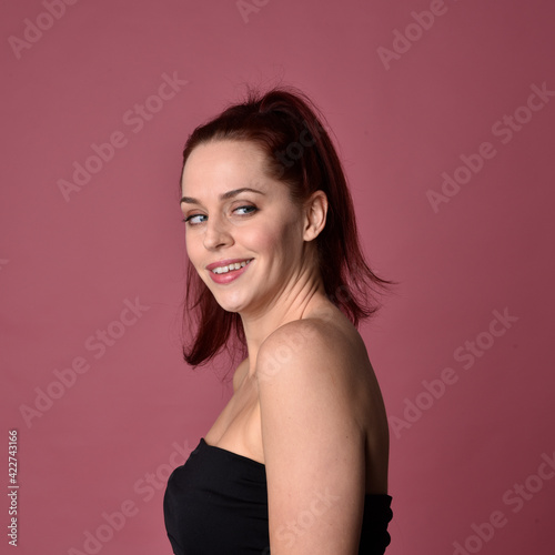 close up portrait of red haired women with different facial expressions on a pink studio background.