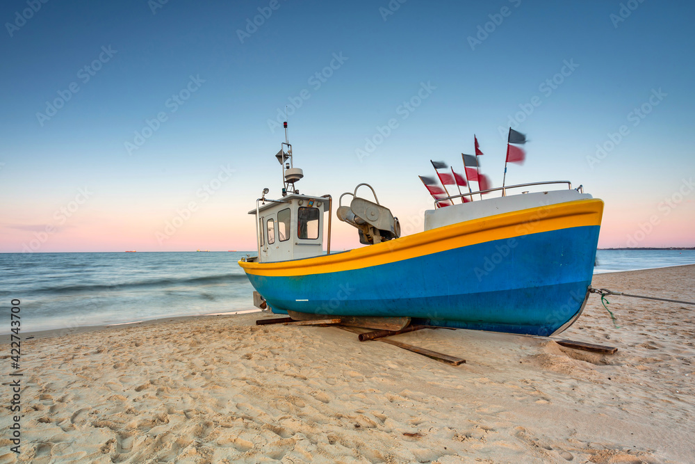 Amazing sunset with fishing boats at the beach of Baltic Sea in Sopot, Poland