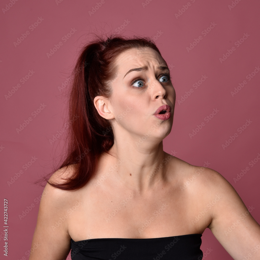 Naklejka premium close up portrait of red haired women with different facial expressions on a pink studio background.