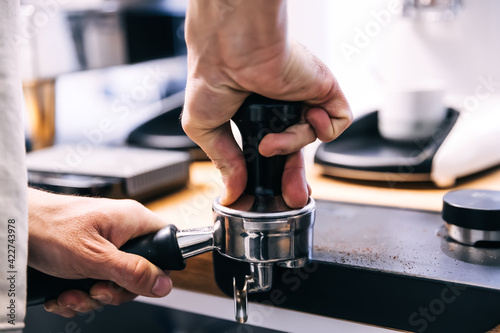 A man with a portafilter in his hands. The concept of making coffee in a coffee machine.