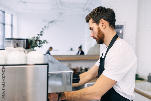 A professional, experienced barista prepares coffee in a coffee