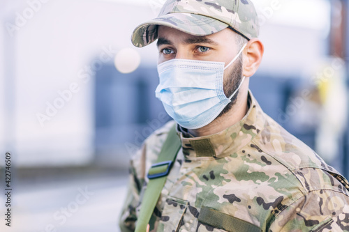 a soldier of the National Armed Forces monitors the safety of people, following the rules, adhering to the COVID-19 prevention protocol, wearing a mask
