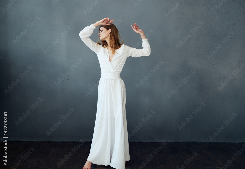 Naklejka premium Romantic woman in full growth on a gray background in a white dress Copy Space
