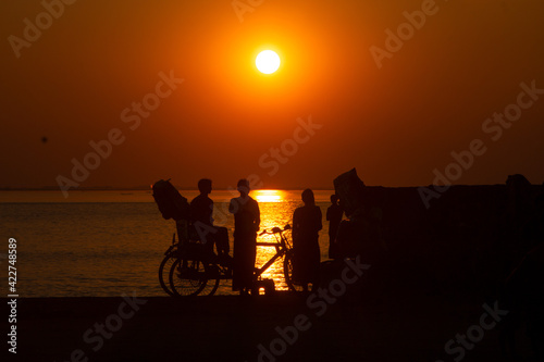 Young couple watching sunset on the a river side