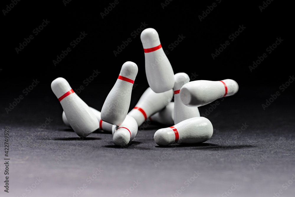 Bowling. Image of knocked down pins on a black background. Copy space. Space for text Bowling. Image of knocked down pins on a black background. Copy space. Space for text