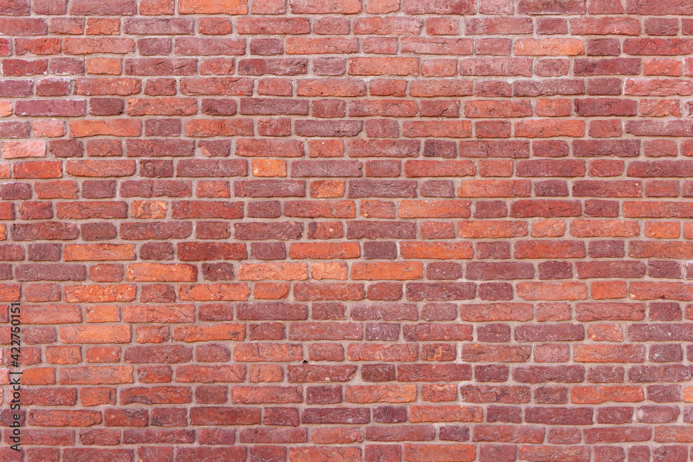 A wall of old, cracked bricks, with a weathered and faded surface. Restored brickwork of an old house. A wall of old, cracked bricks, with a weathered and faded surface. Restored brickwork of an old house.
