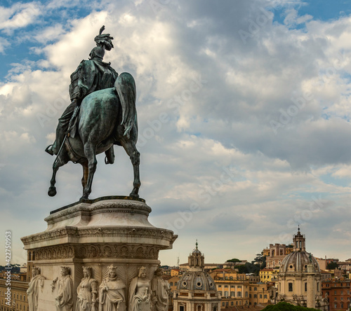 Rome. Bronze statue of a rider on a horse against the background of the city and the blue summer sky