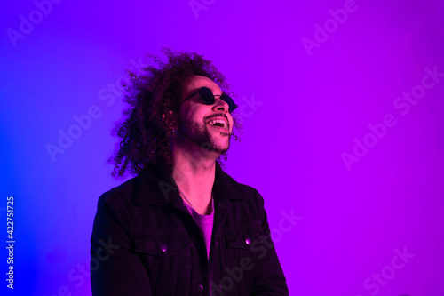 Portrait of an Afro-American hipster man, afro hair, in the style of the 80s and 90s, steampunk glasses, blue and purple neon lights. smiling and laughing