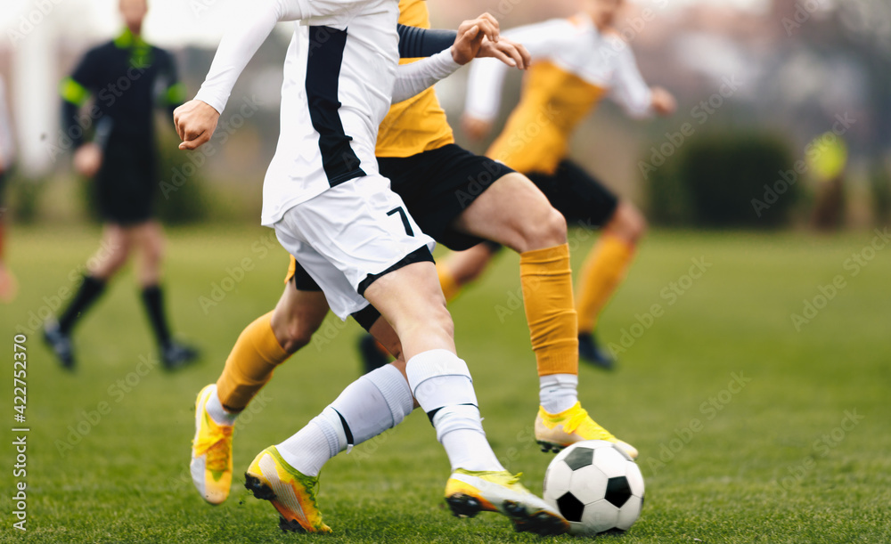 Adult sports players in football duel run. Footballers running ball at the game. Youth soccer league competition match Adult sports players in football duel run. Footballers running ball at the game. Youth soccer league competition match