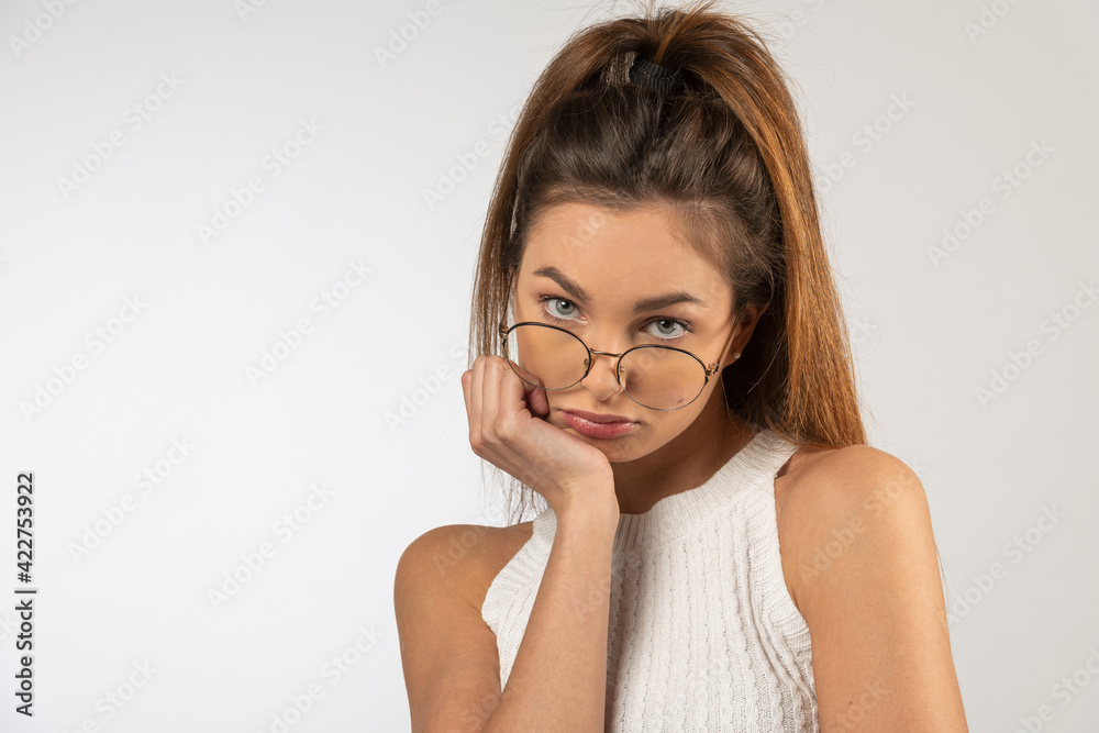 portrait of young lady , with eyeglasses looing in camera angry sad