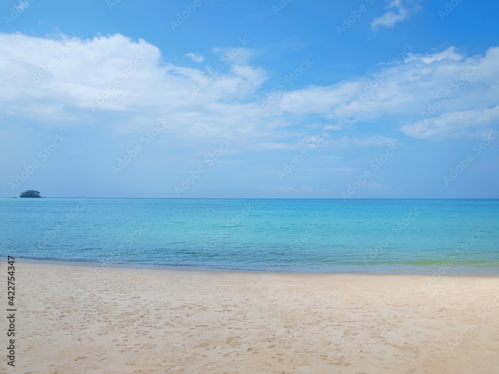 Tropical beach. Sandy coast. Sea view. Blue sky with clouds. Small green island on the horizon. Empty shore. Summer resort. Azure calm water. Bright colors of ocean. Panorama, horizontal frame. Phuket