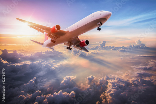 Landscape with aircraft is flying above clouds in the blue sky. Travel background with passenger plane. Commercial airplane. Private jet. Fast Travel and transportation concept photo
