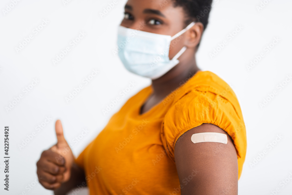 Female Showing Vaccinated Arm And Thumbs-Up Approving Covid-19 Vaccine, Studio Female Showing Vaccinated Arm And Thumbs-Up Approving Covid-19 Vaccine, Studio