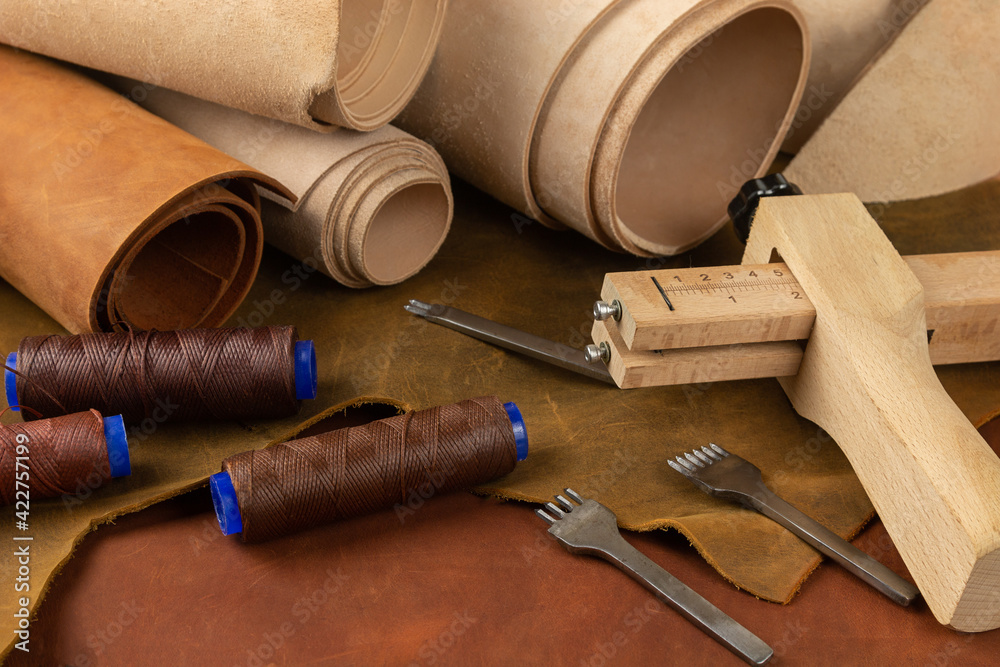 Leather and hand tools stand on a workbench in a leather workshop. Leather workshop concept