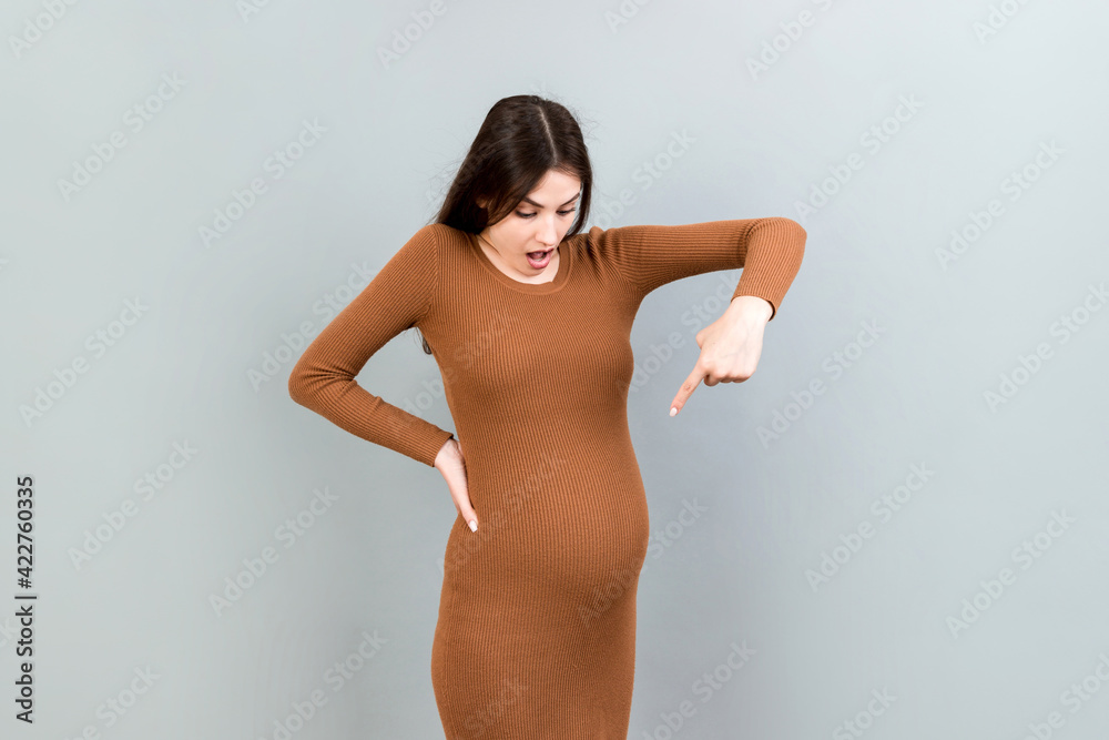 Fototapeta premium Young surprise or shocked woman pregnant isolated colored background. expression female
