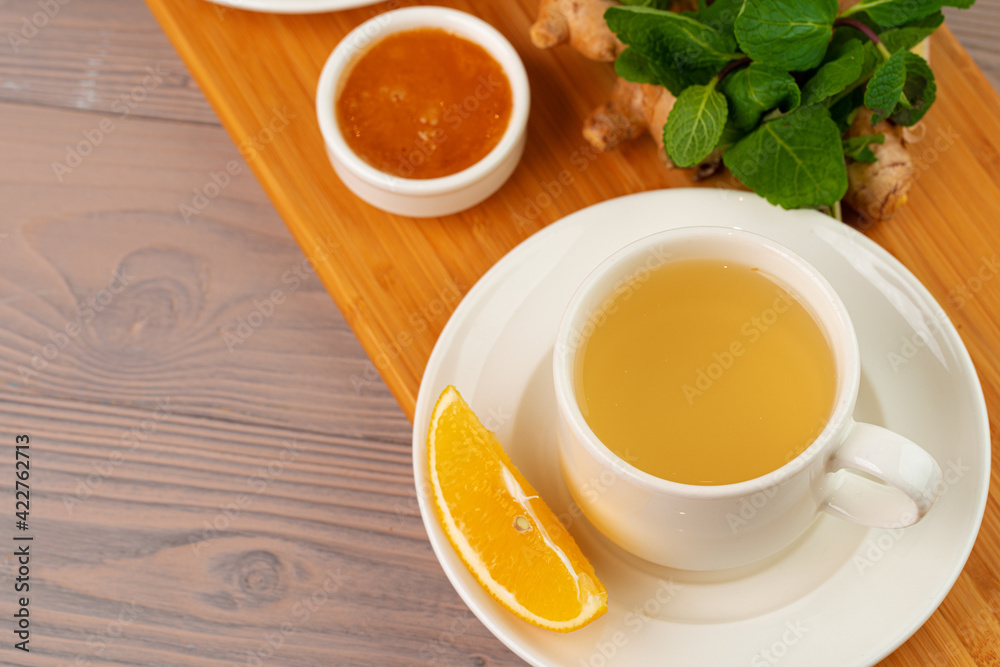 Cup of tea with ginger and mint on wooden table Cup of tea with ginger and mint on wooden table