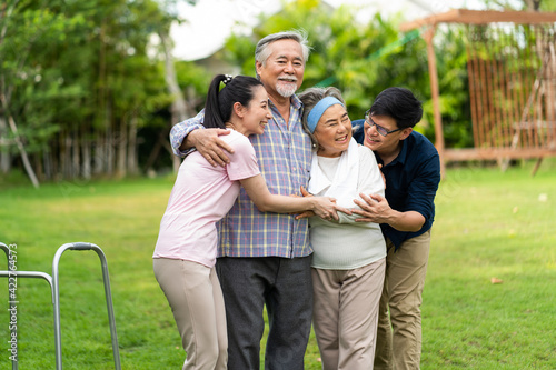Asian family with love. 4 People. happy family shows love by hugging each other on the lawn at home. © NVB Stocker