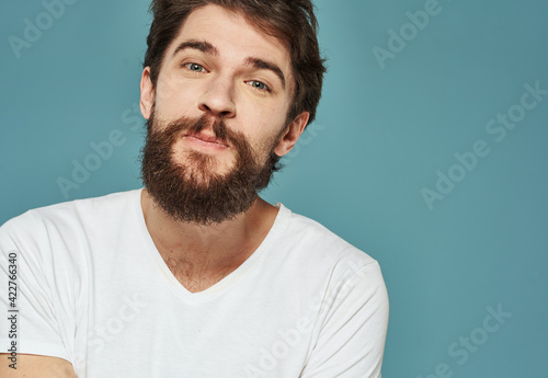 Portrait of a man blue background close-up cropped view white t-shirt handsome smile © SHOTPRIME STUDIO
