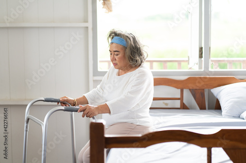 senior woman try to walk in bedroom at home. Elderly peoples and retirement home service concept.