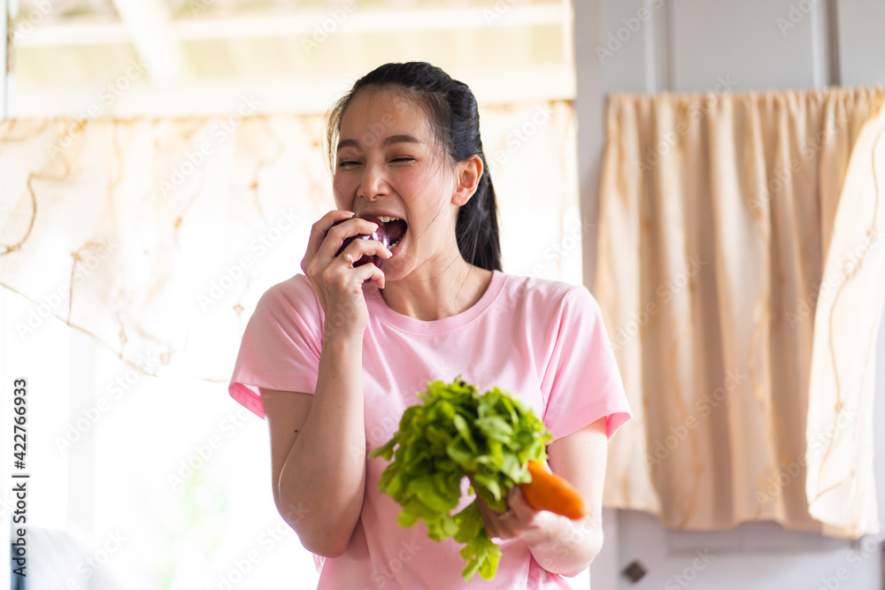 Young Asian Woman with fresh vegetables in her hands. Healthy Lifestyle and Cooking At Home