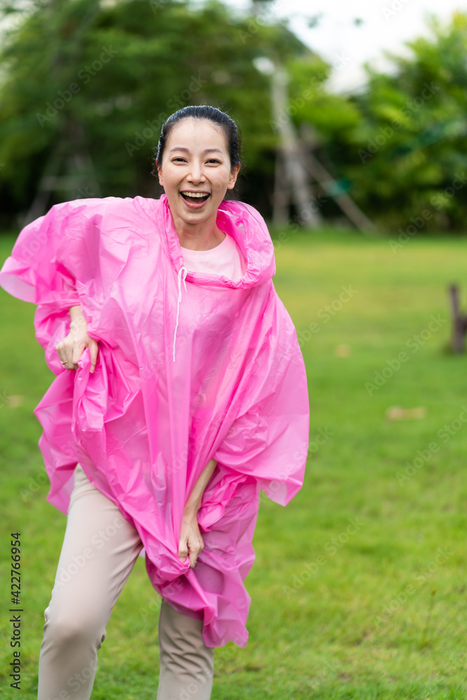 Young beautiful Asian woman wearing a raincoat outdoors Young beautiful Asian woman wearing a raincoat outdoors