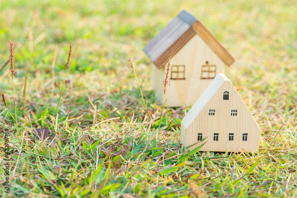 Wooden toy house model on green grass new home Wooden toy house model on green grass new home