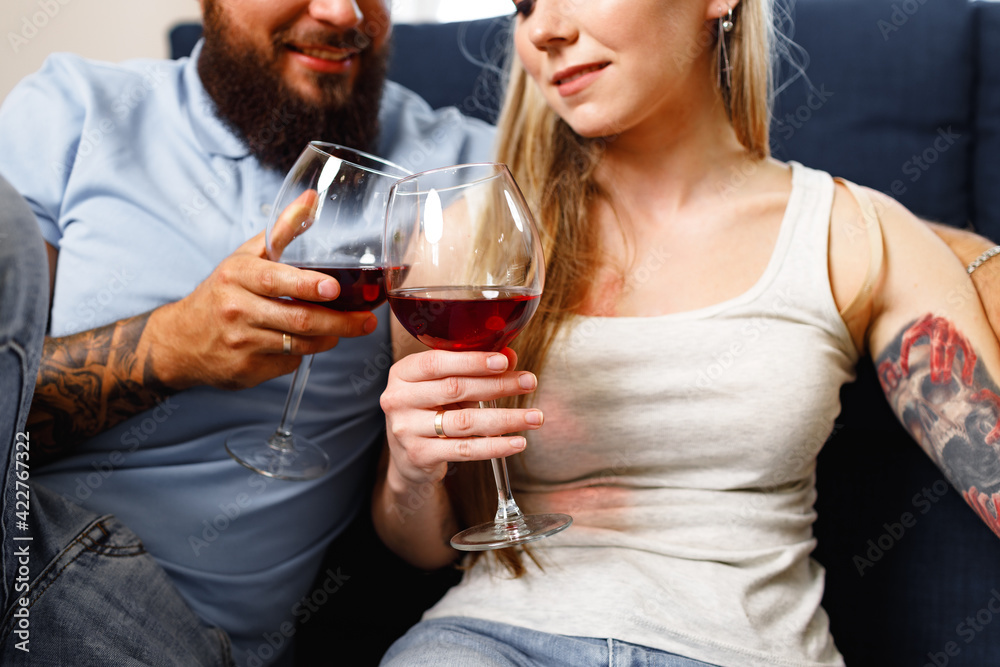 Couple sitting on sofa at home and drinking wine Couple sitting on sofa at home and drinking wine