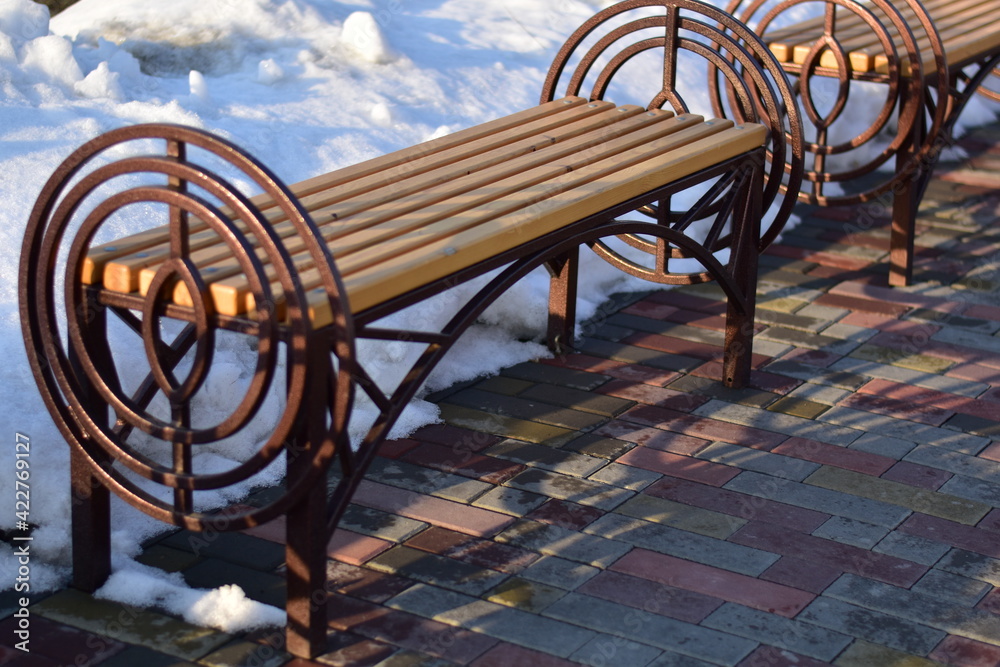 metal and wood bench in a snow-covered park
