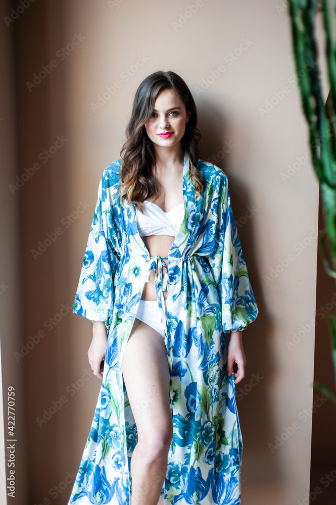 Fototapeta premium Beautiful smiling woman in a light silk tunic for the beach