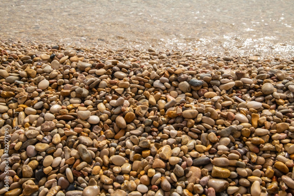 pile of washed up small stones on a beach in close up pile of washed up small stones on a beach in close up
