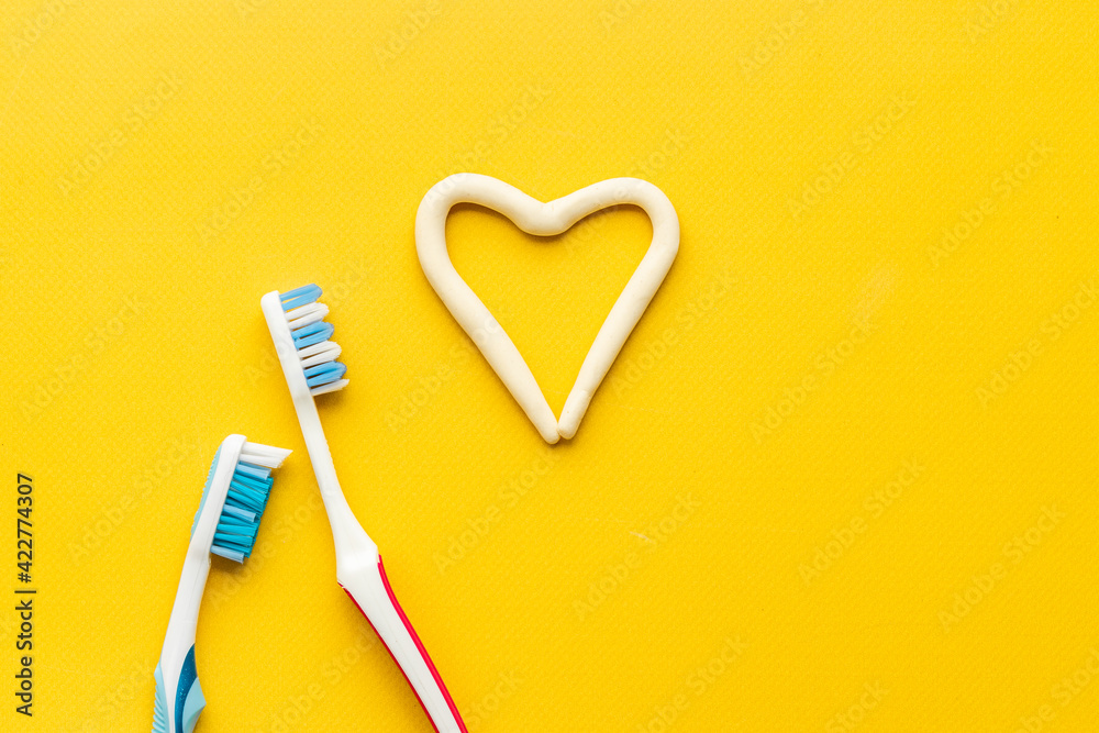 Teeth hygiene. Toothbrush with heart shape made of toothpaste, top view Teeth hygiene. Toothbrush with heart shape made of toothpaste, top view